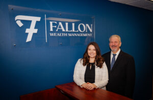 Tim and Ellen in front of Fallon Wealth Management sign